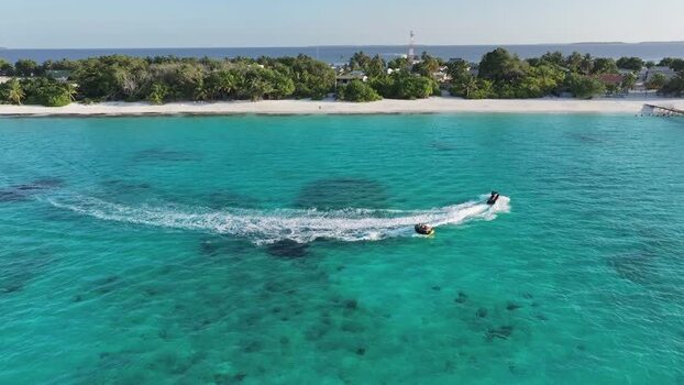 Aerial view of a jet ski pulling a tube Maldives Aerial view of a jet ski pulling a tube Maldives