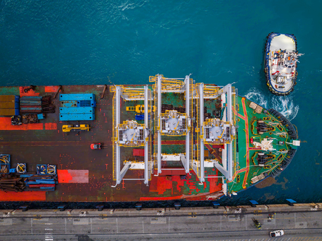 Aerial view of the Caucedo Logistics Center with a cargo ship docked alongside a tugboat in the port of Andres Santo Domingo Dominican Republic. Aerial view of the Caucedo Logistics Center with a cargo ship docked alongside a tugboat in the port of Andres Santo Domingo Dominican Republic.