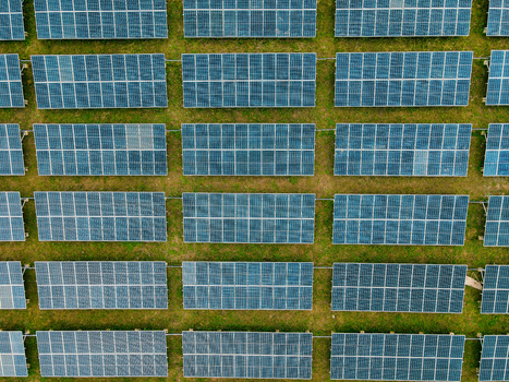 Aerial view of rows of solar panels installed on a grassy field in Ogun State Nigeria.