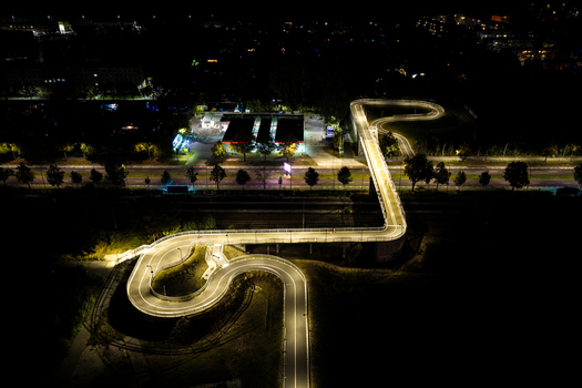 Aerial view of the illuminated Hilde Archenhold Brucke pedestrian bridge at night showing its winding path over the railway tracks in Berlin Berlin Germany. Aerial view of the illuminated Hilde Archenhold Brucke pedestrian bridge at night showing its winding path over the railway tracks in Berlin Berlin Germany.