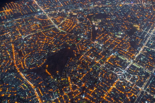 Aerial view of the illuminated urban grid and dense city lights of Karachi at night in Karachi Sindh Pakistan.