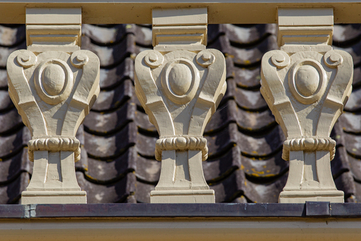 View of the ornate cream colored balusters of Castle Groeneveld with dark roof tiles in the background in Baarn Utrecht Netherlands.
