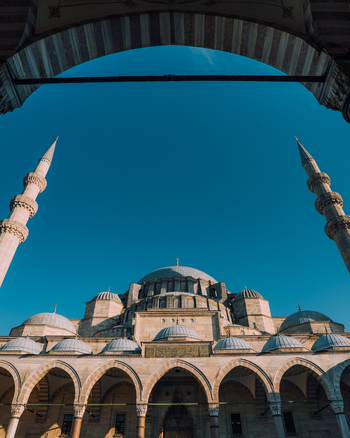 Istanbul Turkiye 03 October 2019 View of the majestic S&uuml;leymaniye Mosque framed by an ornate archway minarets reaching for the deep azure sky a symphony of stone and light.