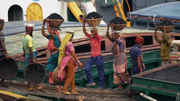 View of workers carrying coal on baskets in Aminbazar Bangladesh. View of workers carrying coal on baskets in Aminbazar Bangladesh.