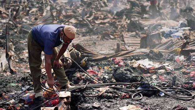View of a man working amidst charred debris and rubble Bangladesh. View of a man working amidst charred debris and rubble Bangladesh.
