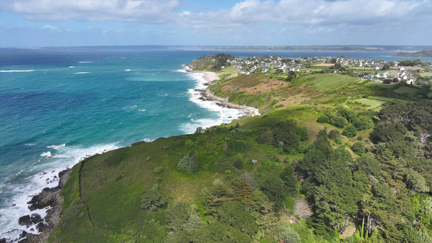 Aerial view of the rugged coastline and turquoise waters of the peninsula with white waves crashing against the rocky shore Locquirec Brittany France. Aerial view of the rugged coastline and turquoise waters of the peninsula with white waves crashing against the rocky shore Locquirec Brittany France.