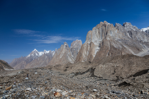 View of Baltoro Glacier with rugged mountain peaks rocky moraine and clear blue sky in Baltoro Gilgit Baltistan Pakistan.