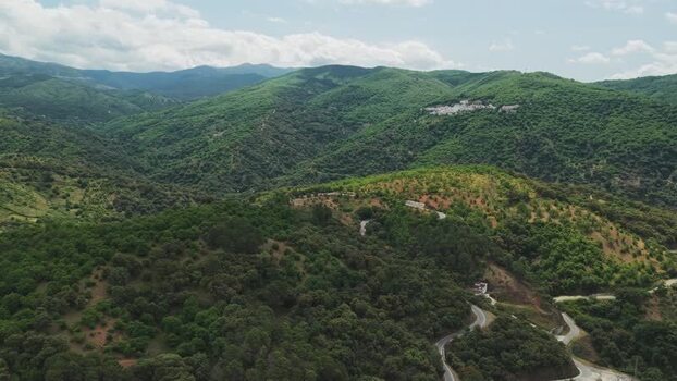 Aerial view of winding mountain roads and lush green hills Spain.