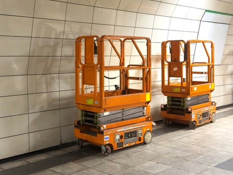 View of two orange scissor lifts parked on a tiled floor in a subway station in Istanbul Istanbul Turkey.