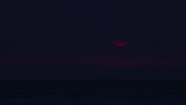 View of the red sun over the dark sea France.