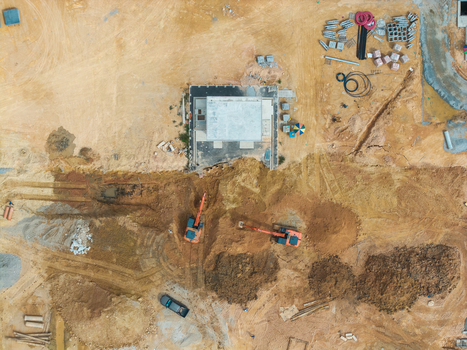 Aerial view of a construction area featuring excavators working on a site with piles of earth building foundations and scattered materials in Bukit Tambun Penang Malaysia. Aerial view of a construction area featuring excavators working on a site with piles of earth building foundations and scattered materials in Bukit Tambun Penang Malaysia.