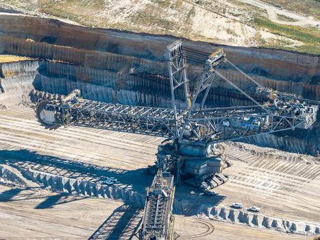 Aerial view of the massive bucket wheel excavator at the Tagebau Welzow Sud open pit mine showing industrial machinery and deep excavation layers in Spremberg Brandenburg Germany. Aerial view of the massive bucket wheel excavator at the Tagebau Welzow Sud open pit mine showing industrial machinery and deep excavation layers in Spremberg Brandenburg Germany.