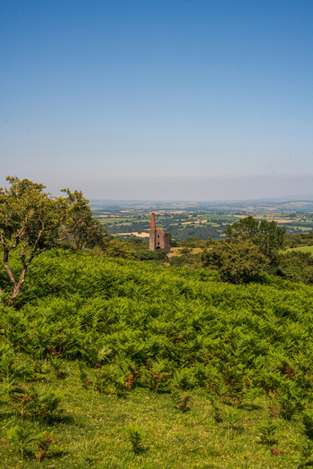 View of the historic Cheesewring stone structure set within the rolling green landscape of Minions Cornwall United Kingdom. View of the historic Cheesewring stone structure set within the rolling green landscape of Minions Cornwall United Kingdom.