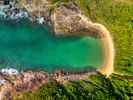 Aerial view of Praia do Ermitao with turquoise water rocky cliffs and dense green vegetation in Guarapari Espirito Santo Brazil. Aerial view of Praia do Ermitao with turquoise water rocky cliffs and dense green vegetation in Guarapari Espirito Santo Brazil.