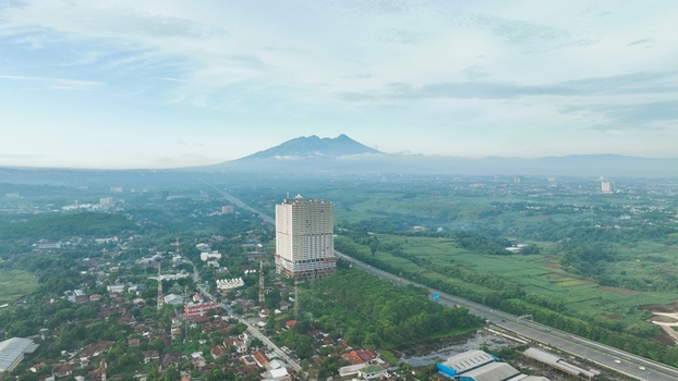 Aerial view of Sentul area featuring a prominent high rise building lush green landscapes and a distant mountain in Babakan Madang West Java Indonesia. Aerial view of Sentul area featuring a prominent high rise building lush green landscapes and a distant mountain in Babakan Madang West Java Indonesia.
