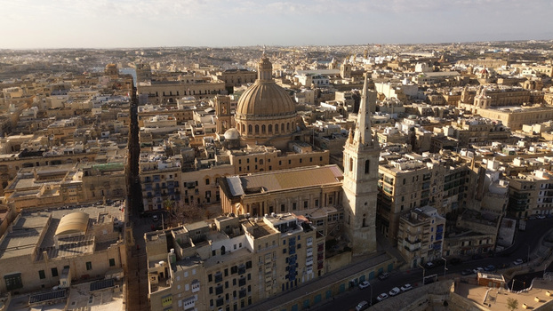 Aerial view of the historic skyline featuring the Basilica of Our Lady of Mount Carmel and St. Paul s Pro Cathedral amidst limestone buildings in Valletta Port Region Malta. Aerial view of the historic skyline featuring the Basilica of Our Lady of Mount Carmel and St. Paul s Pro Cathedral amidst limestone buildings in Valletta Port Region Malta.