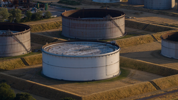 Aerial view of the Tanklager tank farm with large industrial storage tanks surrounded by grassy embankments in Hunxe North Rhine Westphalia Germany.
