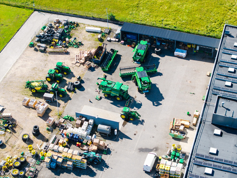 Kekava Latvia 05 July 2026 Aerial view of an agricultural machinery dealership featuring various green tractors and combine harvesters parked in an outdoor storage yard. Kekava Latvia 05 July 2026 Aerial view of an agricultural machinery dealership featuring various green tractors and combine harvesters parked in an outdoor storage yard.