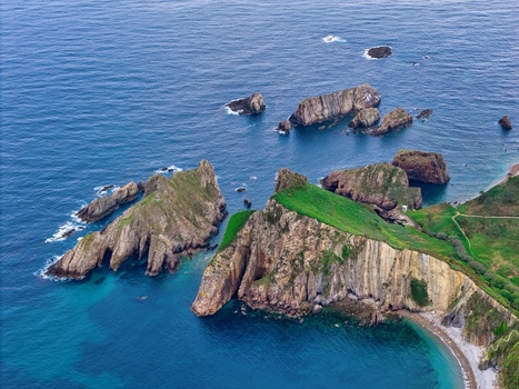Aerial view of Silence Beach Viewpoint with dramatic rocky cliffs and islets surrounded by turquoise ocean water Cudillero Asturias Spain.