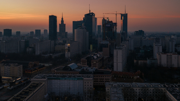 Warsaw Poland 01 March 2026 Aerial view of the modern skyline with skyscrapers and construction cranes under a sunset sky.