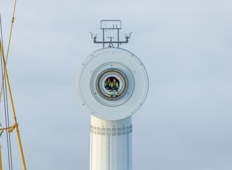 Netherlands 26 November 2025 Aerial view of two technicians in high visibility clothing sitting inside the nacelle of a large offshore wind turbine against a clear sky. Netherlands 26 November 2025 Aerial view of two technicians in high visibility clothing sitting inside the nacelle of a large offshore wind turbine against a clear sky.
