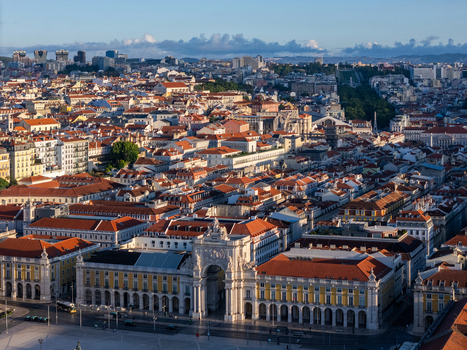 Aerial view of the Rua Augusta Arch and Praca do Comercio surrounded by historic red tiled rooftops and the urban skyline of Lisbon Lisbon Portugal. Aerial view of the Rua Augusta Arch and Praca do Comercio surrounded by historic red tiled rooftops and the urban skyline of Lisbon Lisbon Portugal.