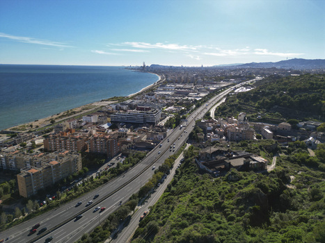 Aerial view of the coastal highway running alongside the Mediterranean Sea with urban residential buildings and green hills in Montgat Catalonia Spain. Aerial view of the coastal highway running alongside the Mediterranean Sea with urban residential buildings and green hills in Montgat Catalonia Spain.