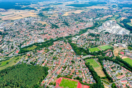 Aerial view of the town of Herzogenaurach with its red roofed houses green sports fields and dense forests under a clear sky Herzogenaurach Bavaria Germany. Aerial view of the town of Herzogenaurach with its red roofed houses green sports fields and dense forests under a clear sky Herzogenaurach Bavaria Germany.