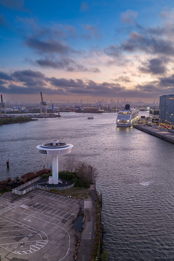 Aerial view of Lighthouse Zero tower and a cruise ship docked at the harbor under a twilight sky in Hamburg Hamburg Germany. Aerial view of Lighthouse Zero tower and a cruise ship docked at the harbor under a twilight sky in Hamburg Hamburg Germany.