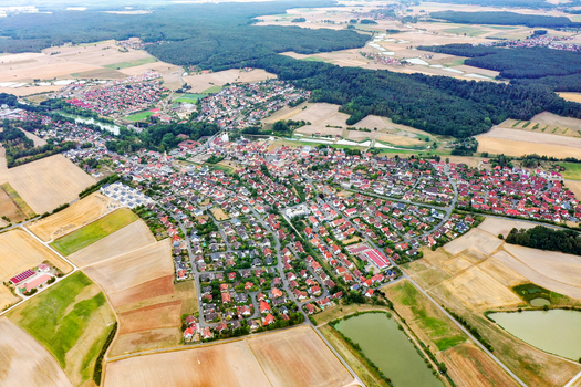 Aerial view of the town of Weisendorf featuring red roofed houses nestled among vast agricultural fields and lush green forests in Weisendorf Bavaria Germany. Aerial view of the town of Weisendorf featuring red roofed houses nestled among vast agricultural fields and lush green forests in Weisendorf Bavaria Germany.