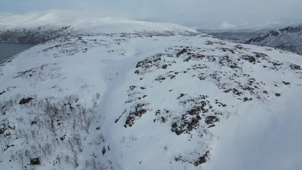 Aerial view of snowy Kvaloya mountain peaks Norway.