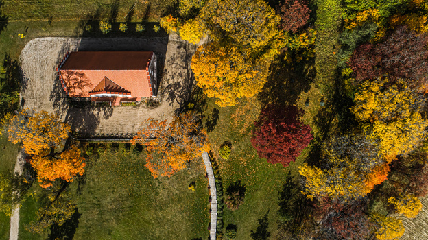 Aerial view of the historic Sigulda Castle grounds surrounded by vibrant autumn foliage with colorful trees and a red tiled roof building in Sigulda Sigulda Municipality Latvia. Aerial view of the historic Sigulda Castle grounds surrounded by vibrant autumn foliage with colorful trees and a red tiled roof building in Sigulda Sigulda Municipality Latvia.