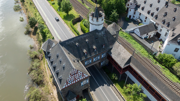 Aerial view of the historic Niederburg castle complex with the main road and railway tracks passing through the stone fortifications in Kobern Gondorf Rheinland Pfalz Germany. Aerial view of the historic Niederburg castle complex with the main road and railway tracks passing through the stone fortifications in Kobern Gondorf Rheinland Pfalz Germany.