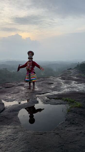View of a traditional Theyyam performer on a rocky hill in Kochi India. View of a traditional Theyyam performer on a rocky hill in Kochi India.