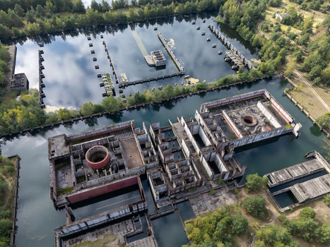 Aerial view of the abandoned Zarnowiec Nuclear Power Plant foundations featuring concrete structures partially submerged in water surrounded by forest in Zarnowiec Poland. Aerial view of the abandoned Zarnowiec Nuclear Power Plant foundations featuring concrete structures partially submerged in water surrounded by forest in Zarnowiec Poland.