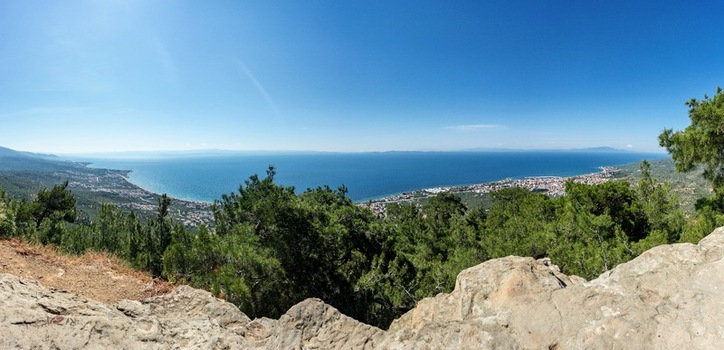 View of the coastal landscape and town nestled among lush green trees overlooking the Aegean Sea from Zeus Altar Adatepe Canakkale Turkey. View of the coastal landscape and town nestled among lush green trees overlooking the Aegean Sea from Zeus Altar Adatepe Canakkale Turkey.