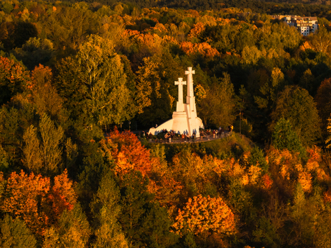 Aerial view of the Three Crosses monument standing proudly amidst a vibrant sea of autumn foliage its white form contrasting with the fiery hues Vilnius Lithuania. Aerial view of the Three Crosses monument standing proudly amidst a vibrant sea of autumn foliage its white form contrasting with the fiery hues Vilnius Lithuania.
