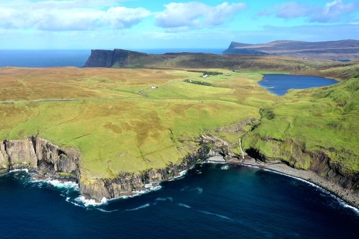 Aerial view of Kilt Rock and Mealt Falls with dramatic basalt cliffs and a waterfall cascading into the sea along the rugged coastline of the Isle of Skye Scotland United Kingdom.