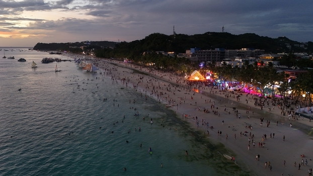 Malay Philippines 02 May 2026 Aerial view of Boracay Island s White Beach crowded with people at sunset featuring sailboats on the water and illuminated resorts along the shore.