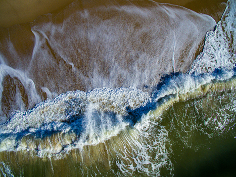 Aerial view of crashing waves at Katama Beach showing the contrast between the sandy shoreline and the deep ocean water in Edgartown Massachusetts United States. Aerial view of crashing waves at Katama Beach showing the contrast between the sandy shoreline and the deep ocean water in Edgartown Massachusetts United States.