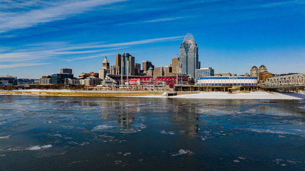 Aerial view of the Cincinnati skyline featuring the Great American Ball Park and ice floes on the Ohio River under a clear blue sky Cincinnati Ohio United States. Aerial view of the Cincinnati skyline featuring the Great American Ball Park and ice floes on the Ohio River under a clear blue sky Cincinnati Ohio United States.