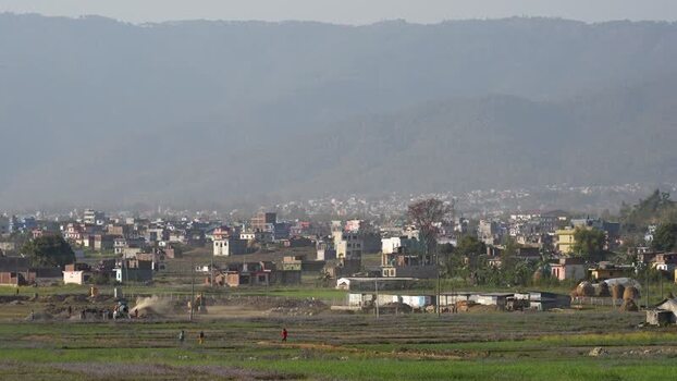 View of a town in a valley with hazy mountains Nepal.