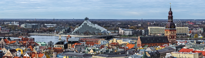Aerial view of the Riga cityscape featuring the National Library of Latvia and the historic Riga Cathedral with red tiled rooftops the Daugava River and urban architecture in Riga Latvia. Aerial view of the Riga cityscape featuring the National Library of Latvia and the historic Riga Cathedral with red tiled rooftops the Daugava River and urban architecture in Riga Latvia.