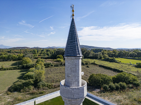 Aerial view of the Lead Mosque minaret rising above the surrounding green fields and rural landscape in Shkoder Shkoder County Albania. Aerial view of the Lead Mosque minaret rising above the surrounding green fields and rural landscape in Shkoder Shkoder County Albania.