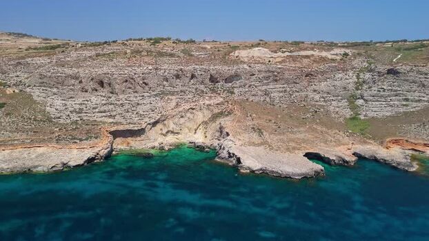 Aerial view of Ghar Lapsi cove Malta with cliffs and turquoise water Aerial view of Ghar Lapsi cove Malta with cliffs and turquoise water