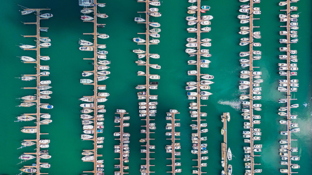Aerial view of numerous white boats docked neatly in rows on the turquoise water of Port du Bloscon creating a striking contrast Roscoff France. Aerial view of numerous white boats docked neatly in rows on the turquoise water of Port du Bloscon creating a striking contrast Roscoff France.