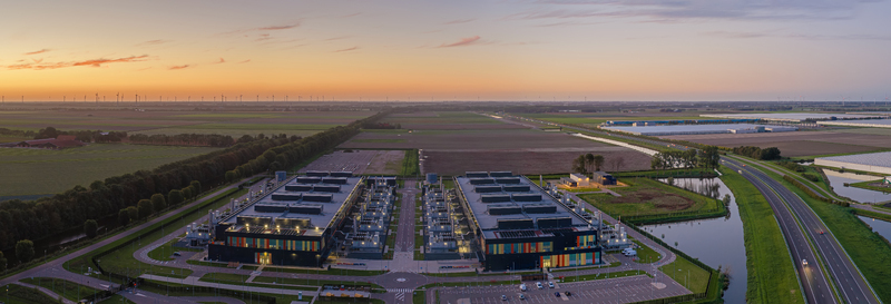 Aerial view of the Microsoft Data Center surrounded by agricultural fields a highway and a canal under a sunset sky in Middenmeer North Holland Netherlands. Aerial view of the Microsoft Data Center surrounded by agricultural fields a highway and a canal under a sunset sky in Middenmeer North Holland Netherlands.