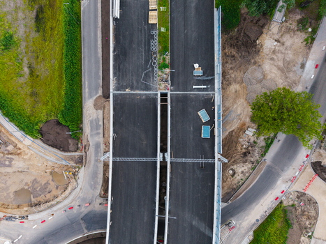 Aerial view of a new road construction site with fresh asphalt construction materials and surrounding greenery in Riga Latvia. Aerial view of a new road construction site with fresh asphalt construction materials and surrounding greenery in Riga Latvia.