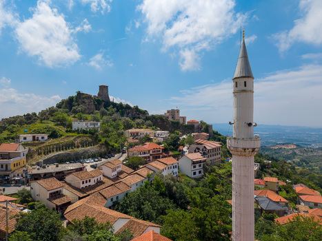 Aerial view of the historic town featuring a white minaret traditional stone houses with red tiled roofs and the ancient castle overlooking Kruje Durres County Albania.