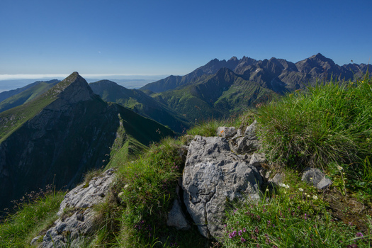 View of the sharp peak of Zdiarska vidla in the Belianske Tatry mountains with rocky foreground and green slopes under a clear blue sky in Zdiar Presov Region Slovakia. View of the sharp peak of Zdiarska vidla in the Belianske Tatry mountains with rocky foreground and green slopes under a clear blue sky in Zdiar Presov Region Slovakia.